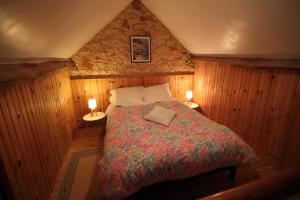 a bedroom with a bed in a room with wooden walls at La Maison de Lassagne in Saint-André-dʼAllas +51 photos