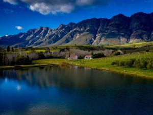 a view of a lake with mountains in the background at Fraaigelegen Farm - Home of ADHARA EVOO in Tulbagh