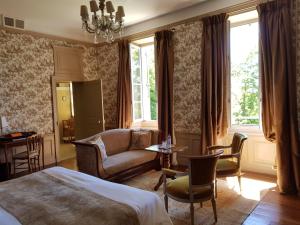 een slaapkamer met een bed, een bank en een tafel bij Château de Lalande - Teritoria - Périgueux in Annesse-et-Beaulieu