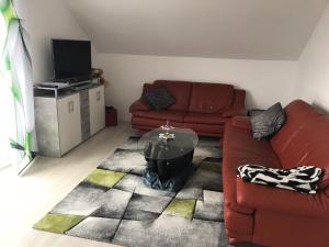 ein Wohnzimmer mit einem Sofa und einem Tisch in der Unterkunft Ferienwohnung im Wonnegau Portugieser-Suite in Flörsheim-Dalsheim