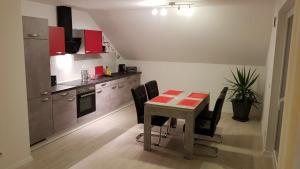 eine Küche mit einem Tisch und schwarzen Stühlen in der Unterkunft Ferienwohnung im Wonnegau Portugieser-Suite in Flörsheim-Dalsheim