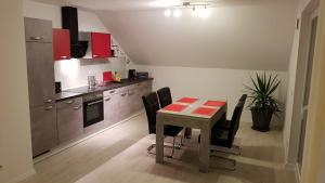 a kitchen with a table and some black chairs at Ferienwohnung im Wonnegau Portugieser-Suite in Flörsheim-Dalsheim