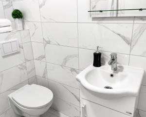 uma casa de banho branca com um WC e um lavatório em Apartments Monako em Herceg Novi