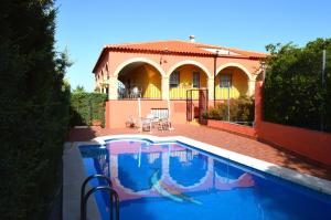 a house with a swimming pool in front of a house at Casa Rural ¨La Noria Olaya¨ in Santa Cruz de Mudela
