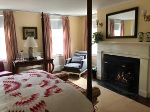 a bedroom with a fireplace and a bed and a mirror at Bridgehampton Inn in Bridgehampton