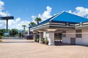 un edificio con techo azul y aparcamiento en Travelodge by Wyndham Deltona, en Deltona