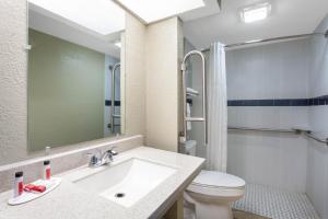 a bathroom with a sink and a toilet at Travelodge by Wyndham Deltona in Deltona