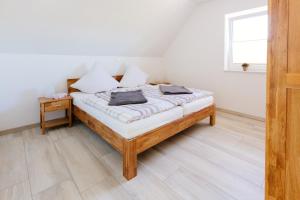 a bedroom with a bed with white walls and a window at Weserrobbe in Bremerhaven