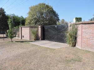 einen Zaun mit einem schwarzen Tor neben einer Ziegelmauer in der Unterkunft Cerros de Salta in Salta