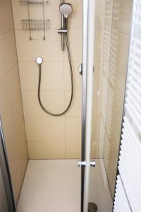 a shower with a hose in a bathroom at Klimatisiertes Loft im Herzen von Deidesheim in Deidesheim