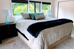 a bedroom with a bed with pillows and a window at The Tides Retreat in Gig Harbor