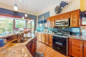 a large kitchen with wooden cabinets and a sink at Casa Corazón @ Eddie beach in Placencia