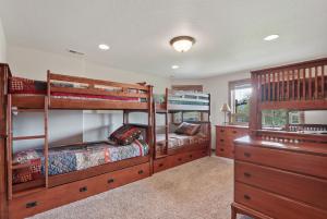 a bedroom with two bunk beds and a dresser at Lakefront Luxury in Sandpoint +29 photos