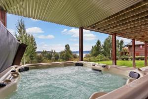 a hot tub in a backyard with a view of the water at Lakefront Luxury in Sandpoint