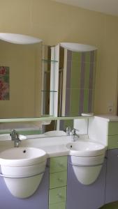 Le gîte d' Alice في La Chapelle-Saint-Martin-en-Plaine: حمام مغسلتين ومرآة