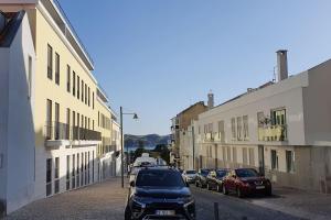 rząd samochodów zaparkowanych na ulicy z budynkami w obiekcie Sweethome w Lizbonie