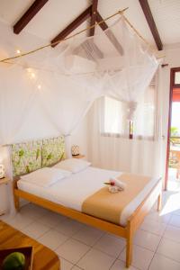 a bedroom with a bed with a mosquito net at Gîtes de Checheti in Trois-Rivières