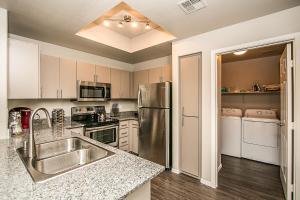 a kitchen with a stainless steel refrigerator and white cabinets at TPC Golf, Shopping & Dining 3 miles with Parking -1064 in Phoenix