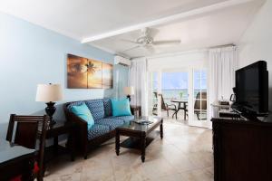 a living room with a couch and a tv at The Club Barbados - All Inclusive - Adults Only in Saint James