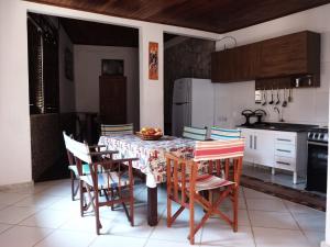y cocina con mesa, sillas y nevera. en neapolis, en Morro de São Paulo