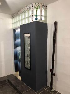 a hallway with a black door with a mirror at Estancia del Sol in Cabo San Lucas