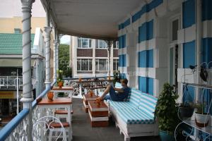 a woman sitting on a couch on a balcony at Urban Hive Backpackers in Cape Town