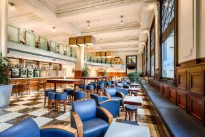 a restaurant with blue chairs and tables at Batman's Hill on Collins in Melbourne