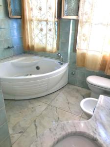 uma casa de banho com uma banheira, um WC e um lavatório. em Villetta Beatrice Versilia - Forte dei Marmi em Marina di Pietrasanta
