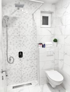 een witte badkamer met een douche en een toilet bij Apartments Monako in Herceg-Novi