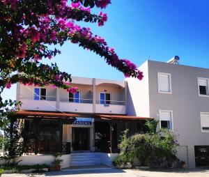 um edifício com flores roxas em frente em Ipanema Hotel em Tigaki