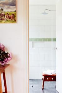a bathroom with a shower with a picture of cows at Tarndwarncoort Homestead in Warncoort