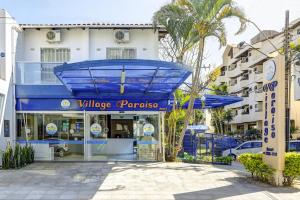 un edificio con toldo azul en una calle en Village Paraíso, en Florianópolis