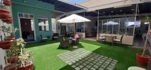 a patio with green grass and an umbrella at Los Andes Bed & Breakfast in Arequipa
