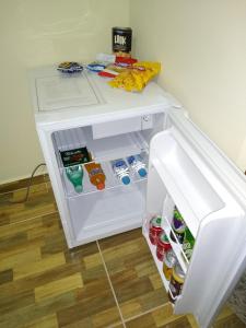 a small white refrigerator with its door open at Pousada Renascer II in Cachoeira Paulista