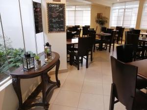 a dining room with tables and chairs and a chalkboard at Belle Sand Hotel in Ica