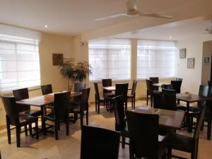 a dining room with tables and chairs and windows at Belle Sand Hotel in Ica