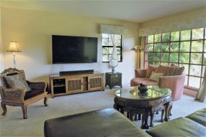 uma sala de estar com um sofá e uma televisão em The Inn at Kulaniapia Falls em Hilo
