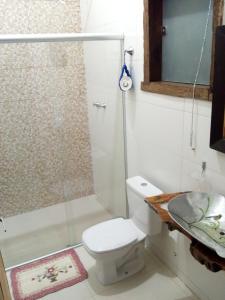 een badkamer met een douche, een toilet en een wastafel bij Pousada Ipoema in Ipoema