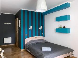 sypialnia z niebiesko-białymi ścianami i łóżkiem w obiekcie Willa Zdrój w Kudowie Zdroju