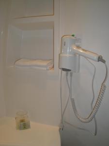 a blow dryer in a white room with a towel at Hotel Talencia in Thouars