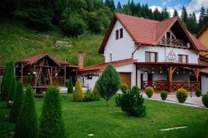a large white house with a red roof at Casa la munte in Bilbor