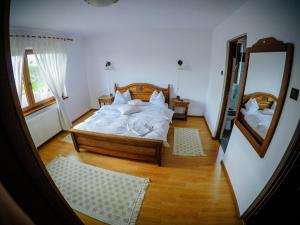 a bedroom with a large bed and a mirror at Casa la munte in Bilbor