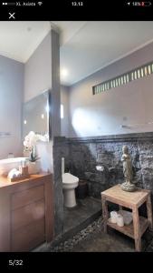 y baño con lavabo, aseo y mesa. en purnama fullmoon resort en Ubud