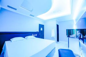 um quarto azul com uma cama e uma cadeira em Amy Motel em Blumenau