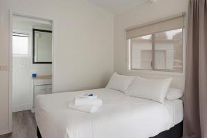 - un lit blanc dans une chambre avec fenêtre dans l'établissement Discovery Parks - Casino, à Casino