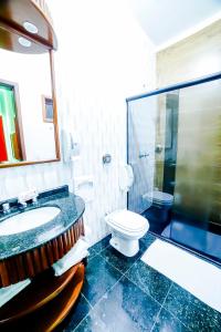 a bathroom with a sink and a toilet and a shower at Amy Motel in Blumenau