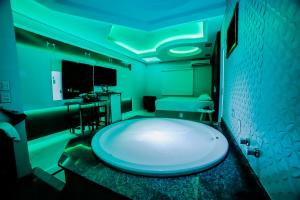 uma casa de banho com uma grande banheira branca num quarto em Amy Motel em Blumenau