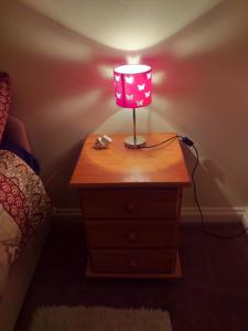 a table with a lamp on top of a dresser at Southernwind - Spareroom in Stanley