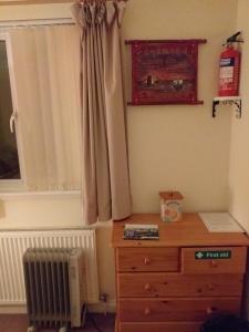 a bedroom with a radiator and a dresser and a window at Southernwind - Spareroom in Stanley