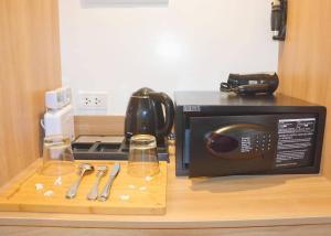 a kitchen counter with a microwave and glasses on a cutting board at Commander Suites de Boracay in Boracay